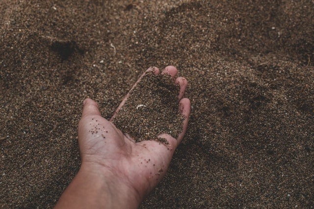 close-up-photo-of-person-holding-sand